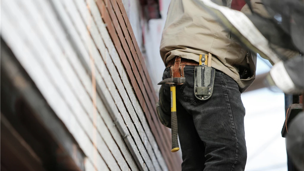 Man Wearing Black Denim Pants With Carrying Hammer on Holster